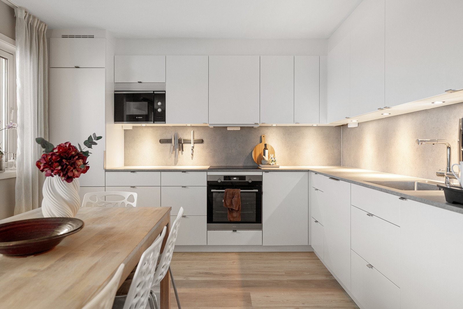 Lekkert og nyere (2022) kjøkken fra kvalitetsleverandøren Kvik. Kjøkkenet framstår funksjonelt med rikelig med skap- og benkeplass.