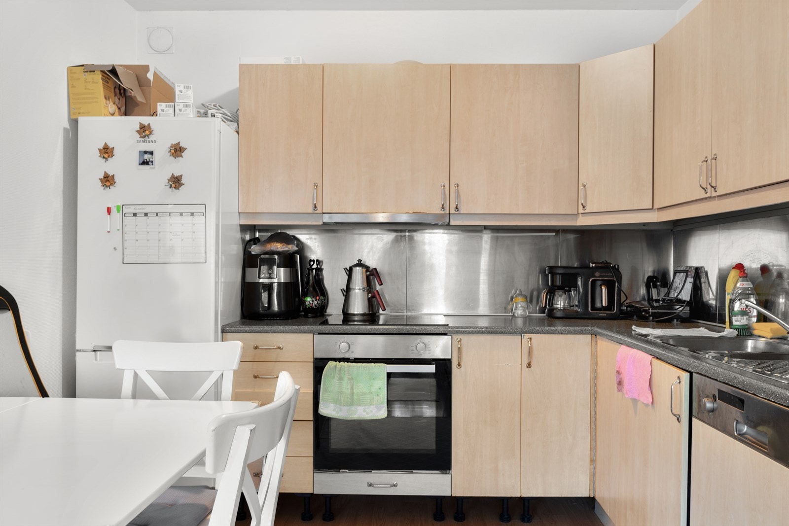 Kjøkkeninnredning med glatte fronter. Stålplate på vegg over benkeskap. Benkeplate med nedfelt kum i rustfritt stål. Kullfilterventilator. Stekeovn og platetopp er integrert i innredningen. Opplegg for oppvaskmaskin Galleribilde