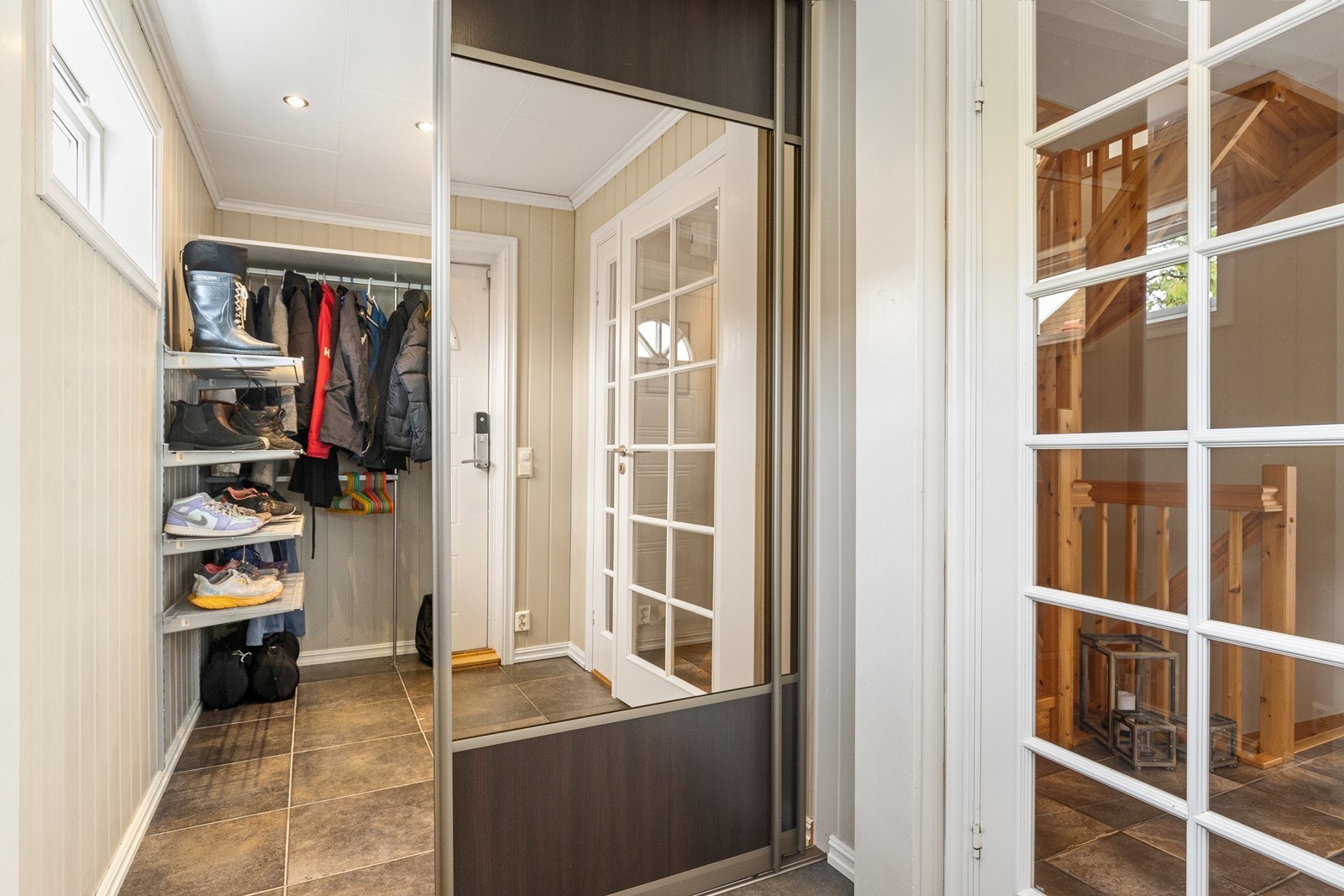 Entré med stort garderoberom adskilt med speilskyvedører Galleribilde