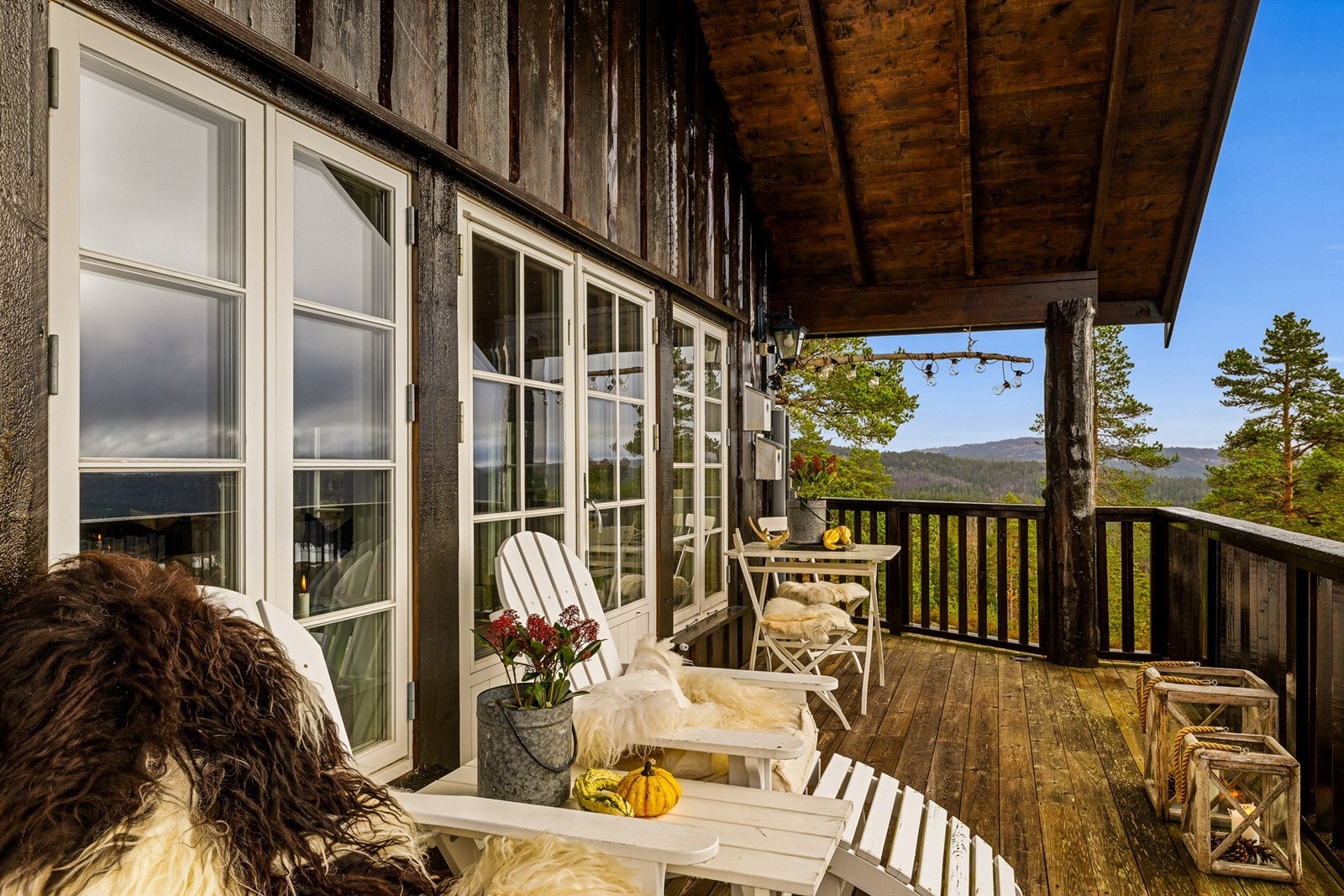 Takoverbygget gjør det enkelt å ha møbler stående ute hele året. Solide stokker som bærer overbygget gir hytta et barskt preg og står fint til kledningen. Galleribilde