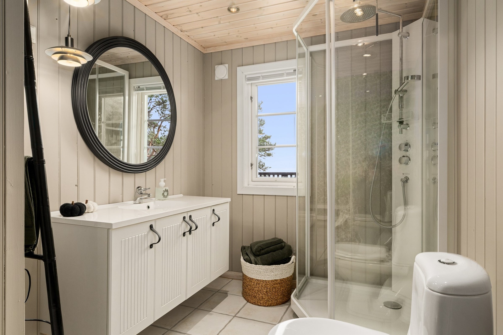 Badet med mulighet for badstue på innsiden ligger i forbindelse med entréen og to av soverommene. Veggene er nylig malt i en lys grå farge og med tapetsert fondvegg på motstående side. Galleribilde