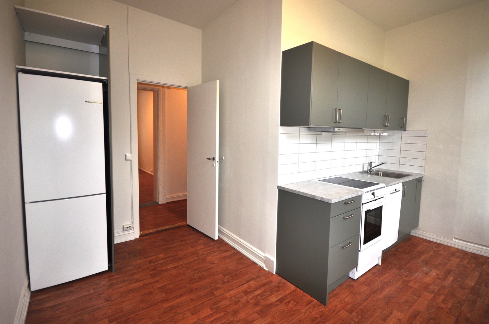 Nytt HTH kjøkken med hvitevarer som kombiskap, komfyr med induksjonstopp og oppvaskmaskin. Galleribilde