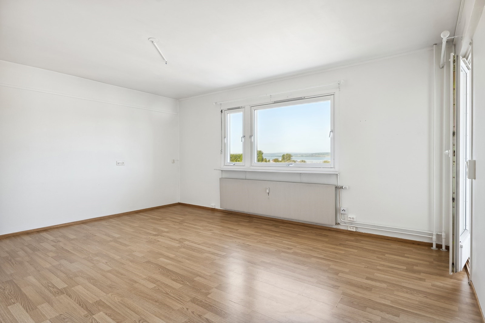 Store vindusflater og lyse farger gir en luftig atmosfære i stuen. Galleribilde