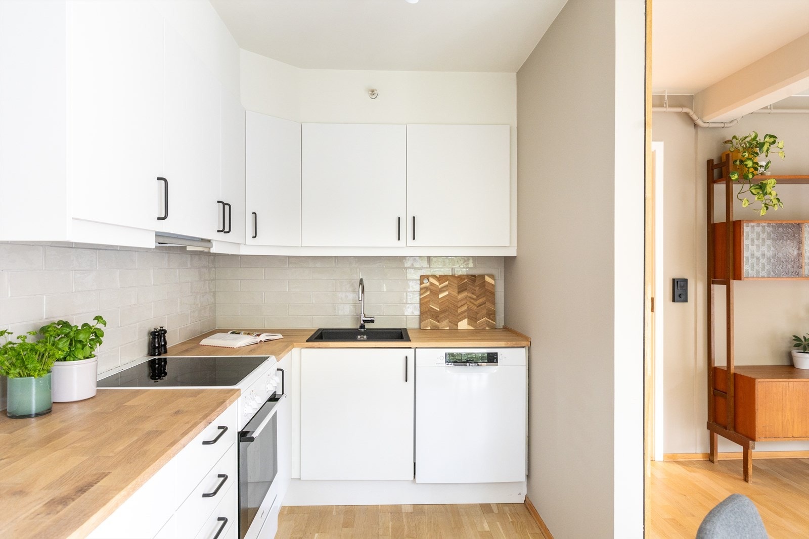 - Kjøkkeninnredning med glatte fronter og heltre benkeplate(2025) med nedfelt vask. Avtrekk over kokeplass(2025) - Galleribilde