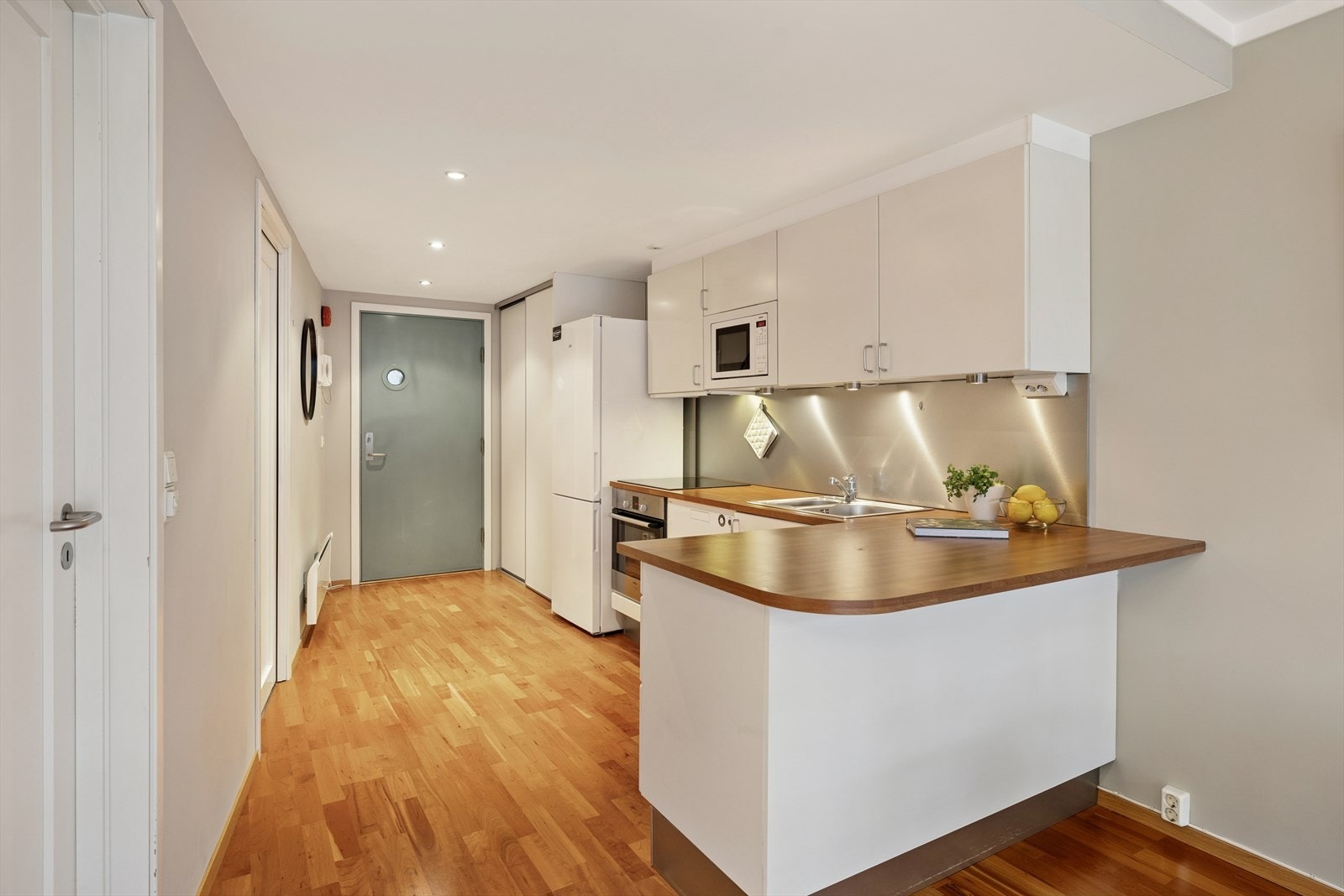 Kjøkkeninnredningen fra 2006 er pen og tidløs, med hvite, glatte fronter og brun laminatbenkeplate med nedfelt kjøkkenkum. Galleribilde