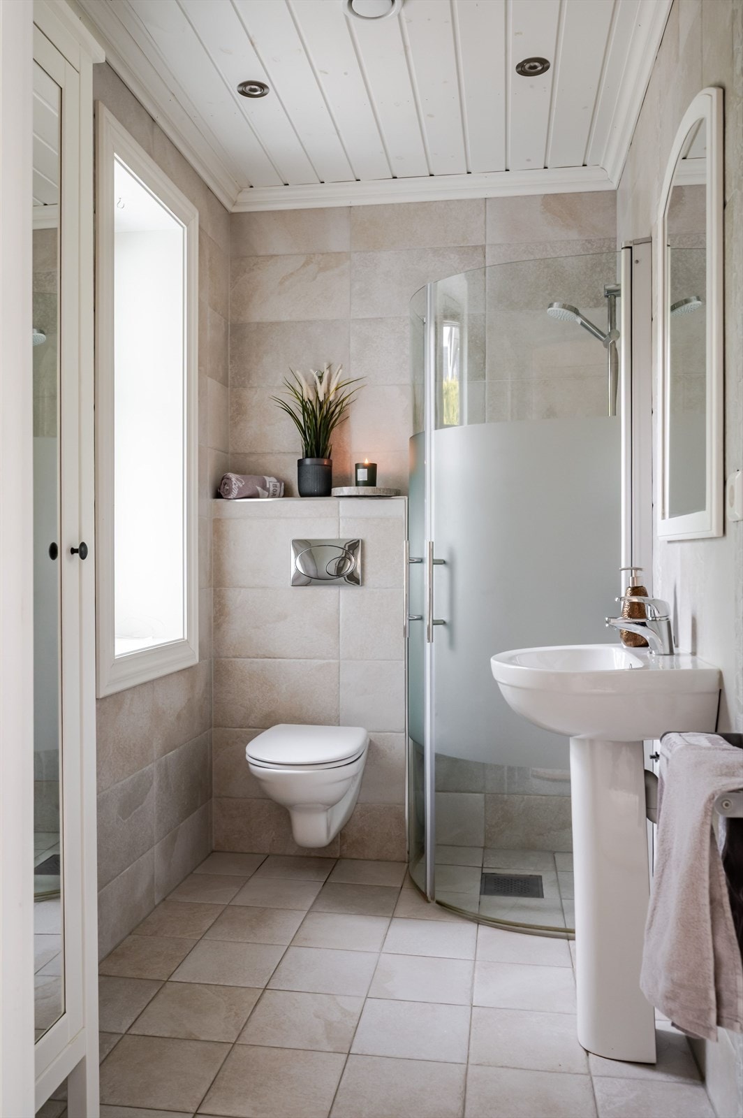 Det andre baderommet i hovedetasjen har samme delikate utførelse. Baderommet er utstyrt med en flott søyleservant med speil over, dusjhjørne med glassdører, vegghengt toalett og et gulvstående høyskap. Galleribilde