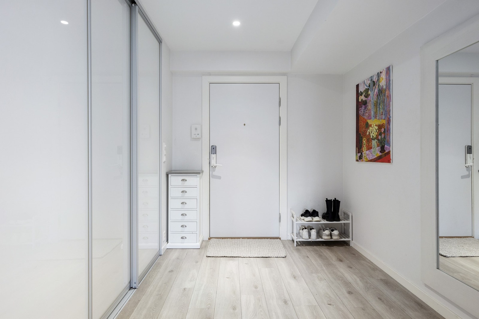 Lys entré med plass til oppheng av klær og sko - inn til garderoberom bak skyvedøren. Galleribilde