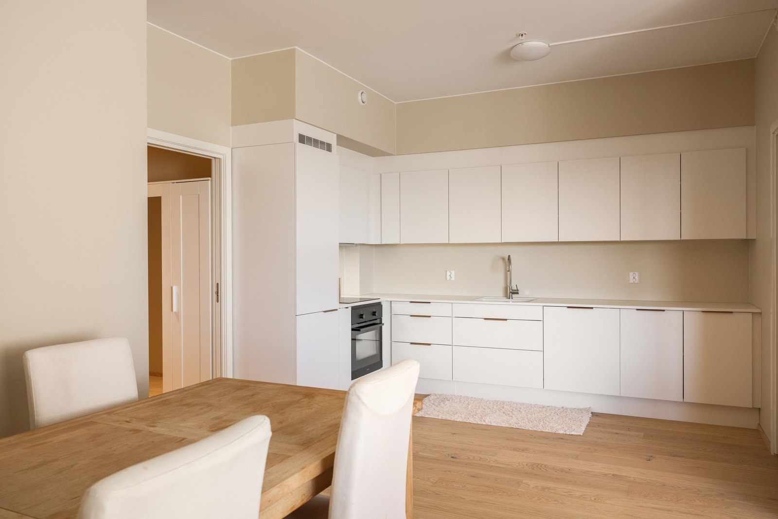 Lekkert kjøkken med hvite, slette fronter og laminat benkeplate Galleribilde