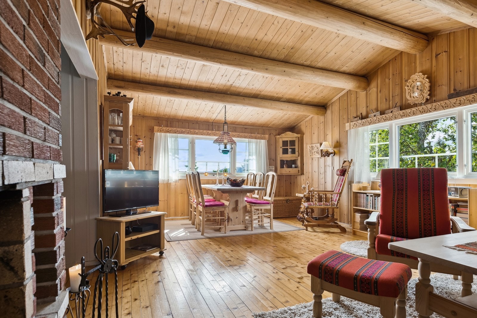 Inne i hytta er det koselig stue med mønet himling og fine tømmeråser. Galleribilde