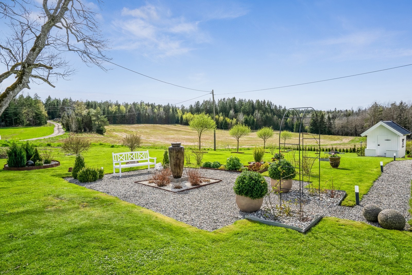 Hagen utenfor våningshuset ligger solrikt vendt mot syd og er pent opparbeidet med en singlet uteplass, trær og busker. Galleribilde