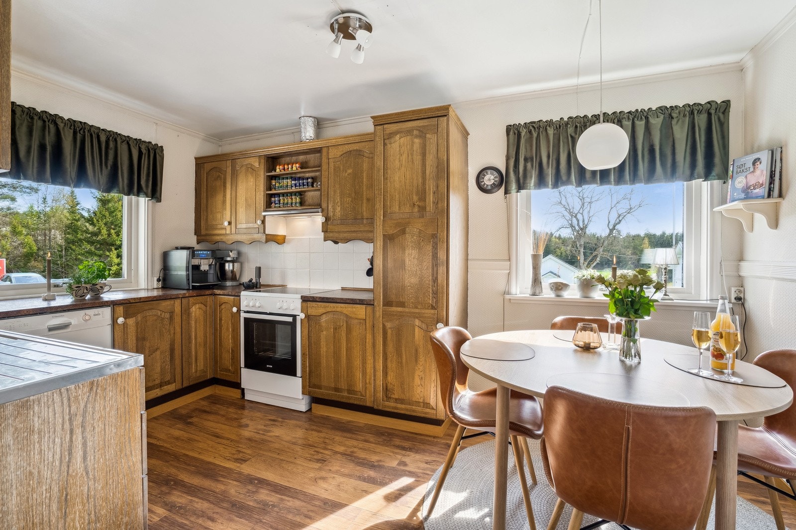 Kjøkkenet i kårboligen har en funksjonell innredning med trehvite fronter og god plass til spisebord. Galleribilde