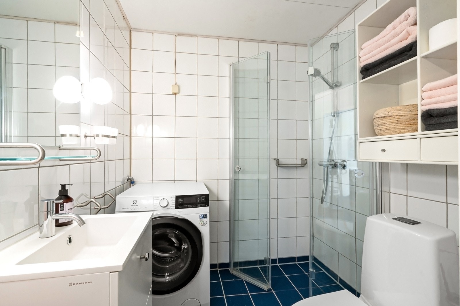 Flislagt baderom med varmekabler. Rommet er innredet med servant med innredning, speil, belysning, dusjhjørne med innfellbare glassdører og toalett. Det er opplegg for vaskemaskin. Avtrekk Galleribilde