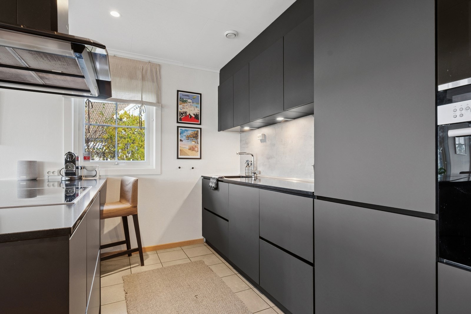 Kjøkkeninnredningen er fra 2019 og fremstår moderne med sorte, glatte fronter og slitesterk benkeplate med underlimt vask i kompositt. Galleribilde