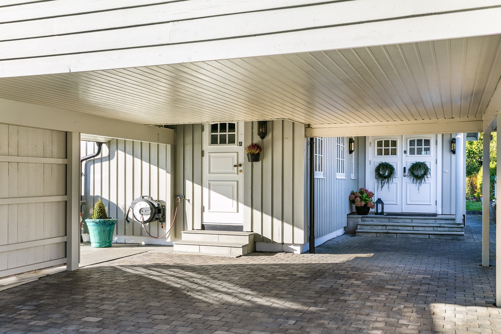 Kjøkkeninngang tilknyttet carporten gjør hverdagen litt enklere. Her kan matvarene bæres inn og avfall tas ut. I hovedentreens trapp er det varmekabler. Galleribilde