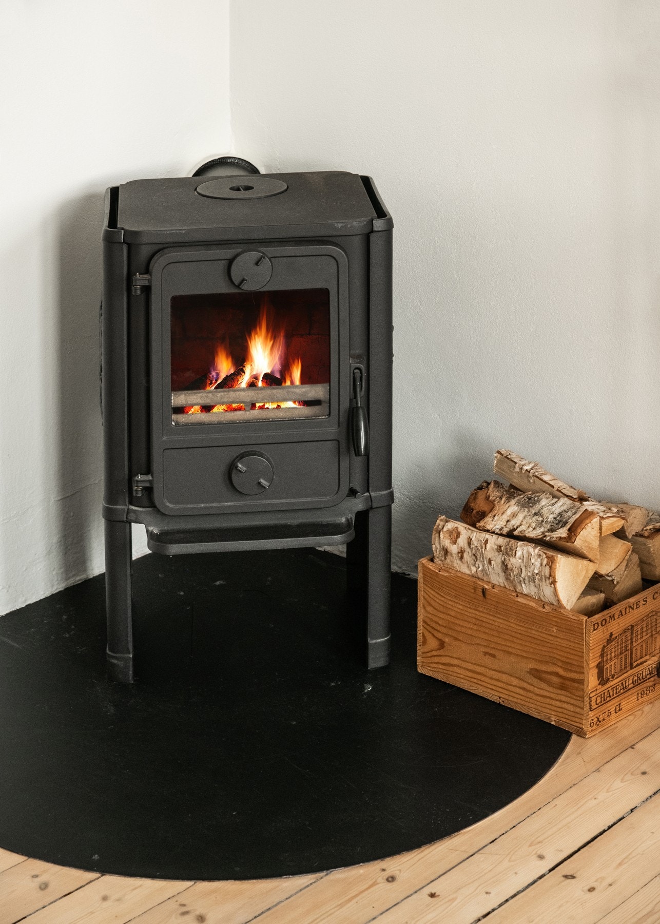 Den vedfyrte peisovnen med glassdør, plassert på en ildfast plate, tilfører både hygge og et naturlig samlingspunkt på kjølige dager. Galleribilde