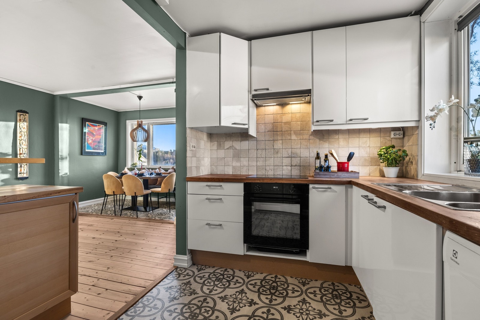 Praktisk kjøkken med hvite fronter og heltre benkeplate. Galleribilde