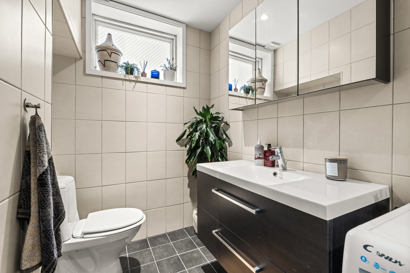 Hovedbadet ble oppusset i 2014 og har fliser på både vegger og gulv, dusjhjørne med glassdører, vegghengt toalett og servant med underskap. Galleribilde