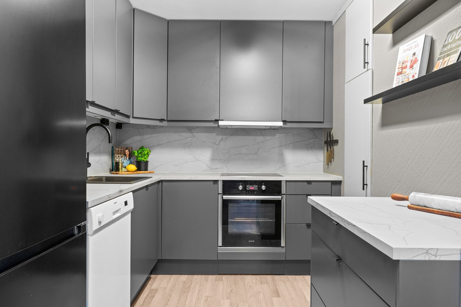 Moderne kjøkken fra 2022 med slette, grå fronter og integrert stekeovn og platetopp. Galleribilde