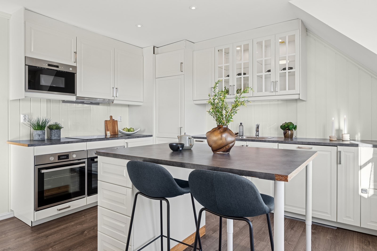 Et stort og godt kjøkken hvor man har rikelig med skap- og skuffeplass, samt gode arbeidsflater på benk på en kjøkkenøy som også fungerer som en romdeler og inviterer til sosial matlagning. Galleribilde