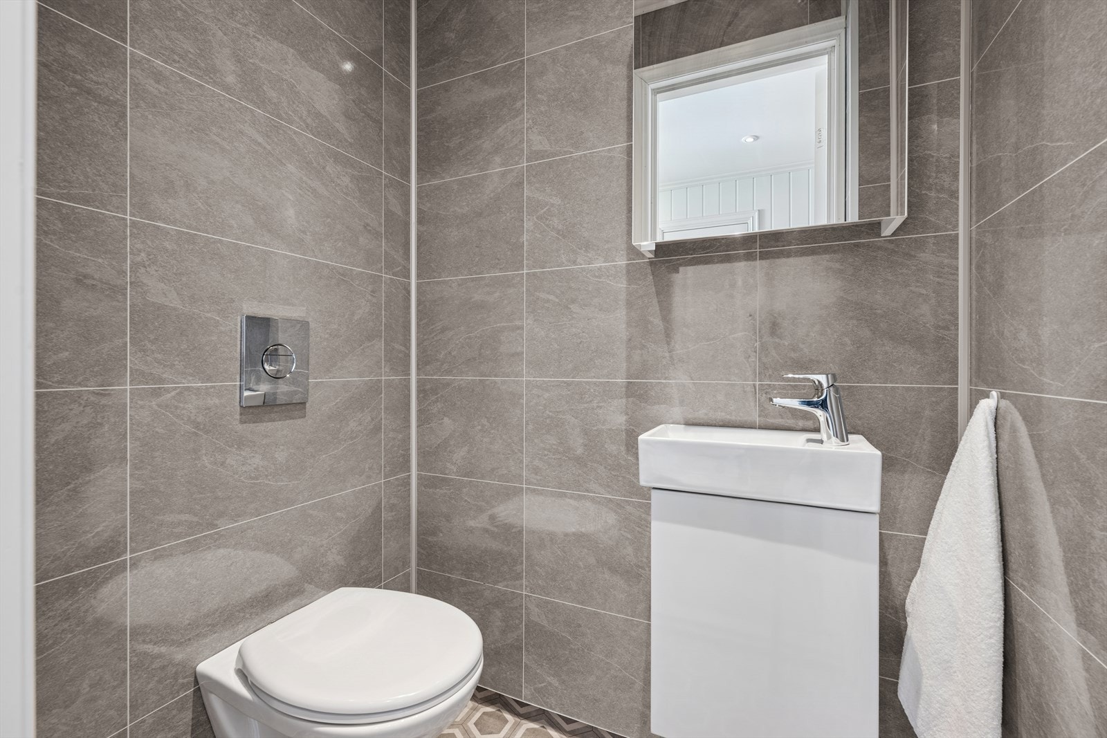 Like ved baderommet finner man et toalettrom som er innredet i tilsvarende stil som baderommet og utstyrt med vegghengt toalett og baderomsinnredning med servant. Galleribilde