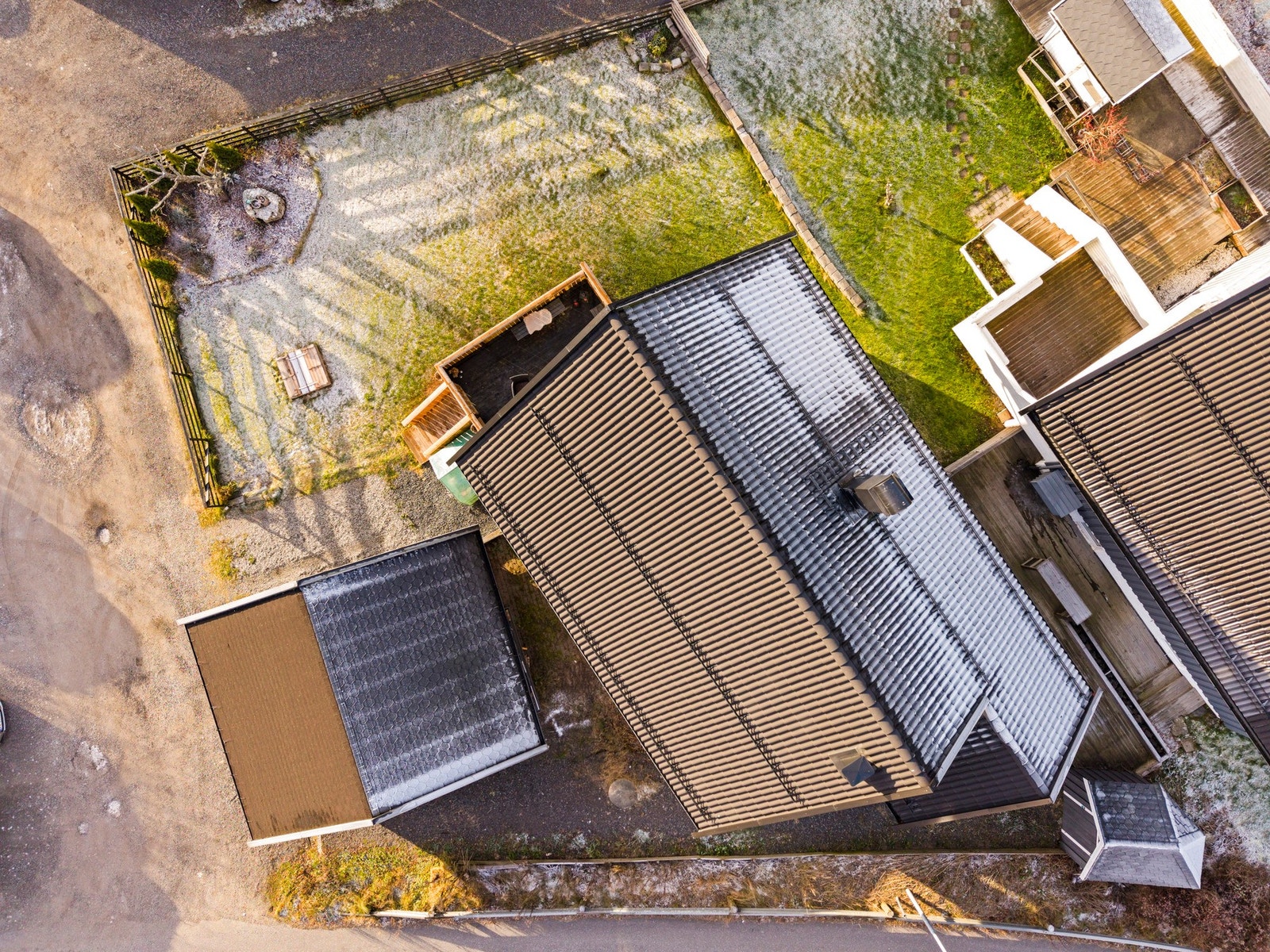 Tomten er pent opparbeidet med gressplen og beplantning, og byr på flere soner for både lek og avslapning Galleribilde