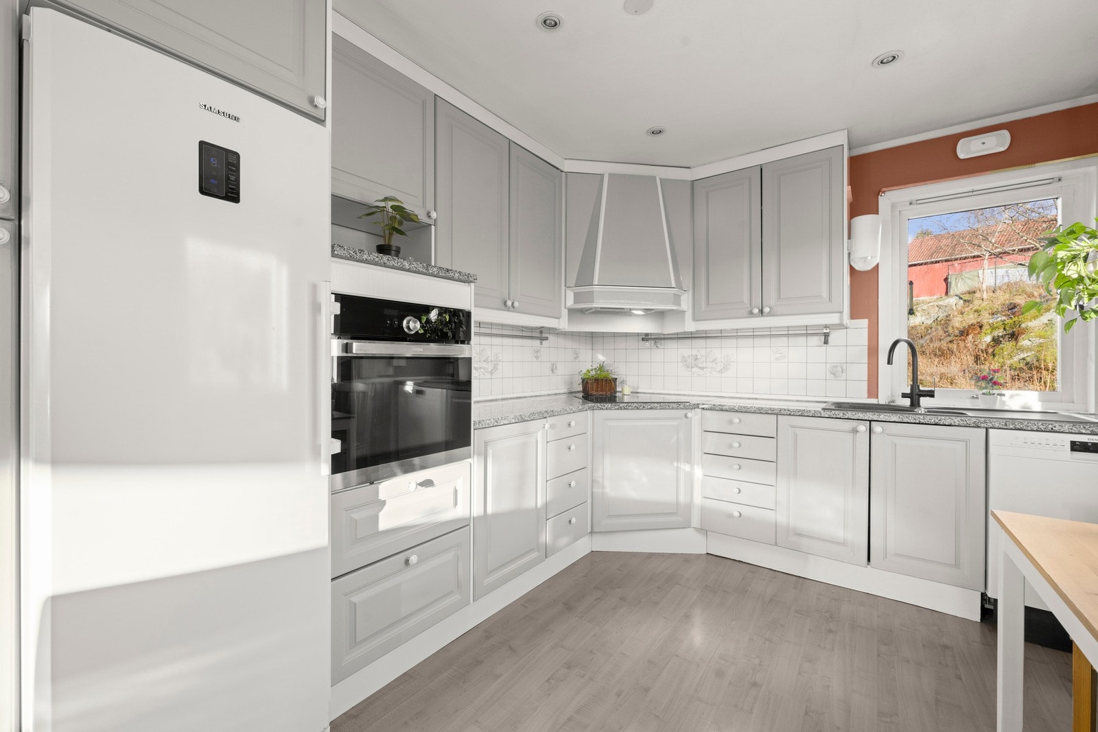 Lyst kjøkken med profilerte fronter, benkeplate i steinkompositt og skyllekum i plastkompositt Galleribilde