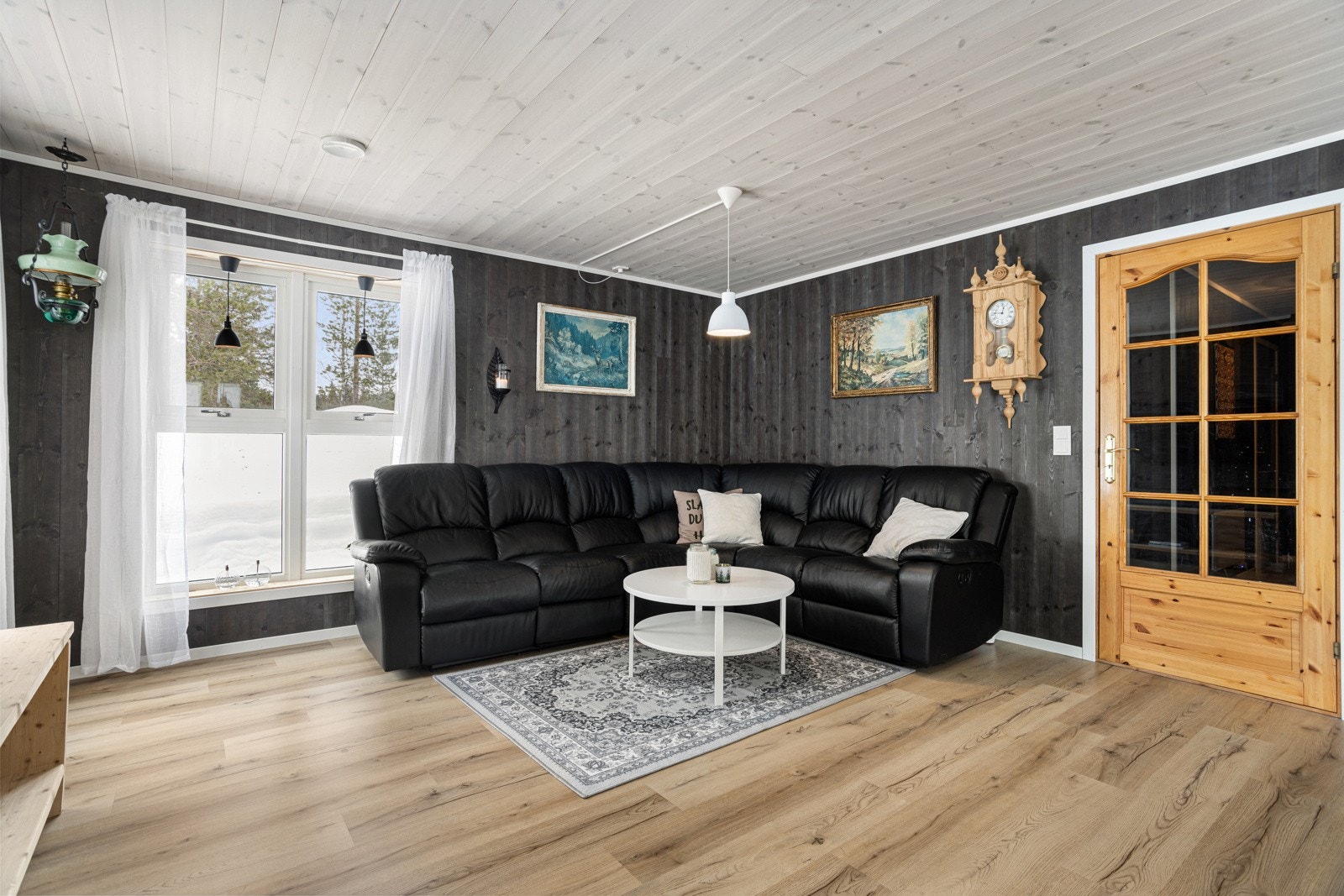 Beiset panel på vegg og 1-stavs parkett på gulv bidrar til en lun romfølelse. Galleribilde