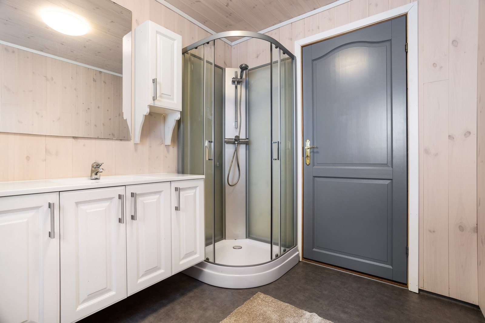 Baderom med dusjkabinett, innredning med servant, forbrenningstoalett og urinal. Galleribilde