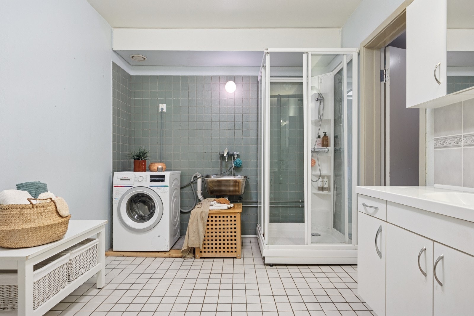 Badet er forøvrig utstyrt med klosett, dusjkabinett, servantskap, vegghengte skap og har opplegg for vaskemaskin. Galleribilde