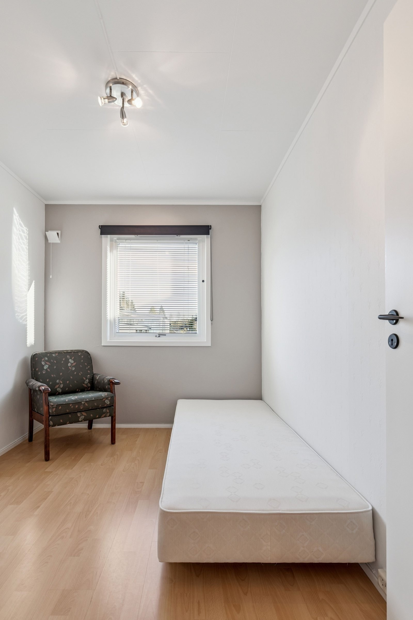 Soverom 1, nymalte flater. Med seng og en kommode. Persienne og rullegardin for solavskjerming. Galleribilde