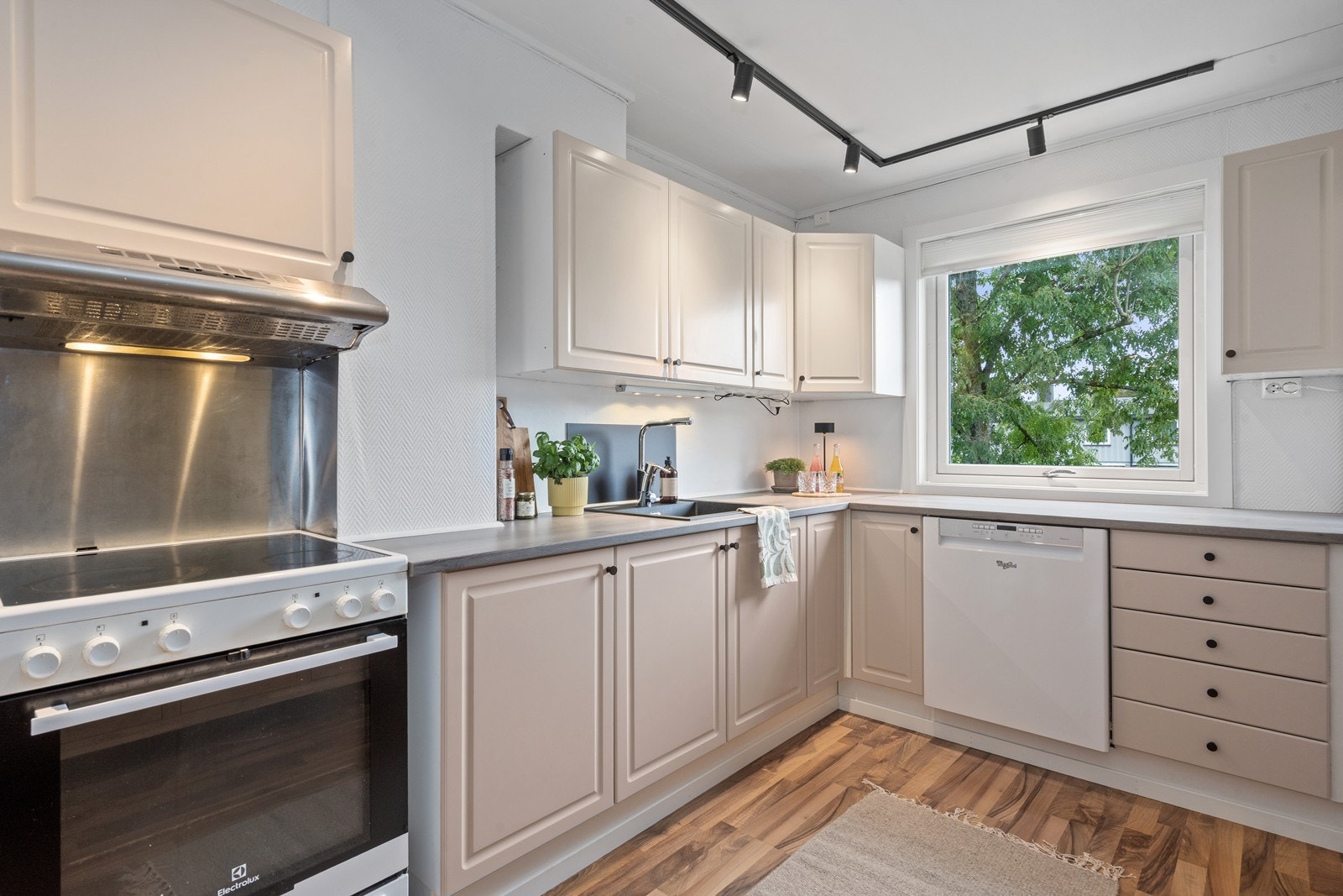 Kjøkkeninnredning med ukjent alder. Kjøkkenet har profilerte fronter og laminat benkeplate. Frittstående komfyr og kjøleskap, underbygget oppvaskmaskin. Galleribilde