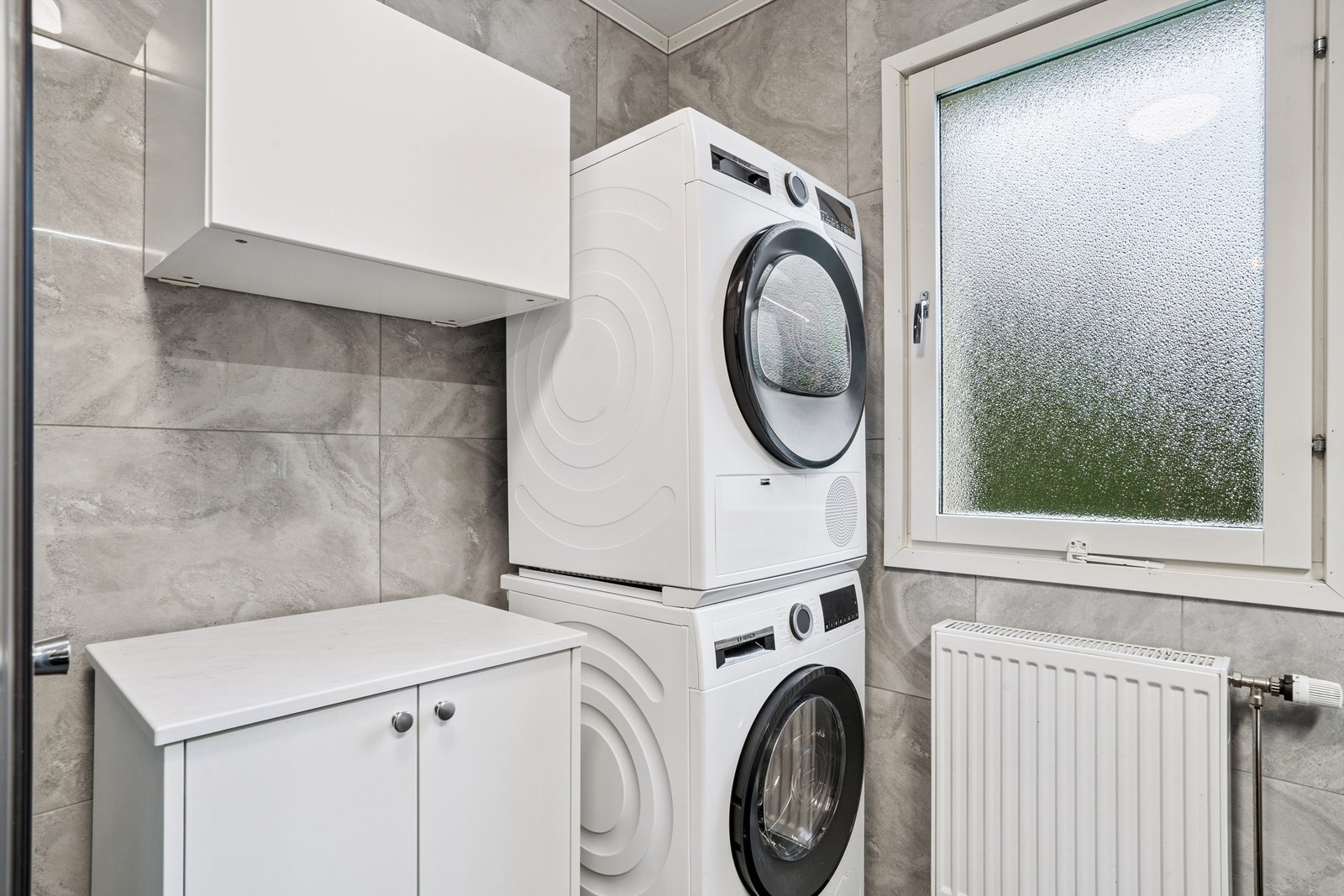 Rommet er praktisk innredet med opplegg for vaskemaskin og tørketrommel. Galleribilde