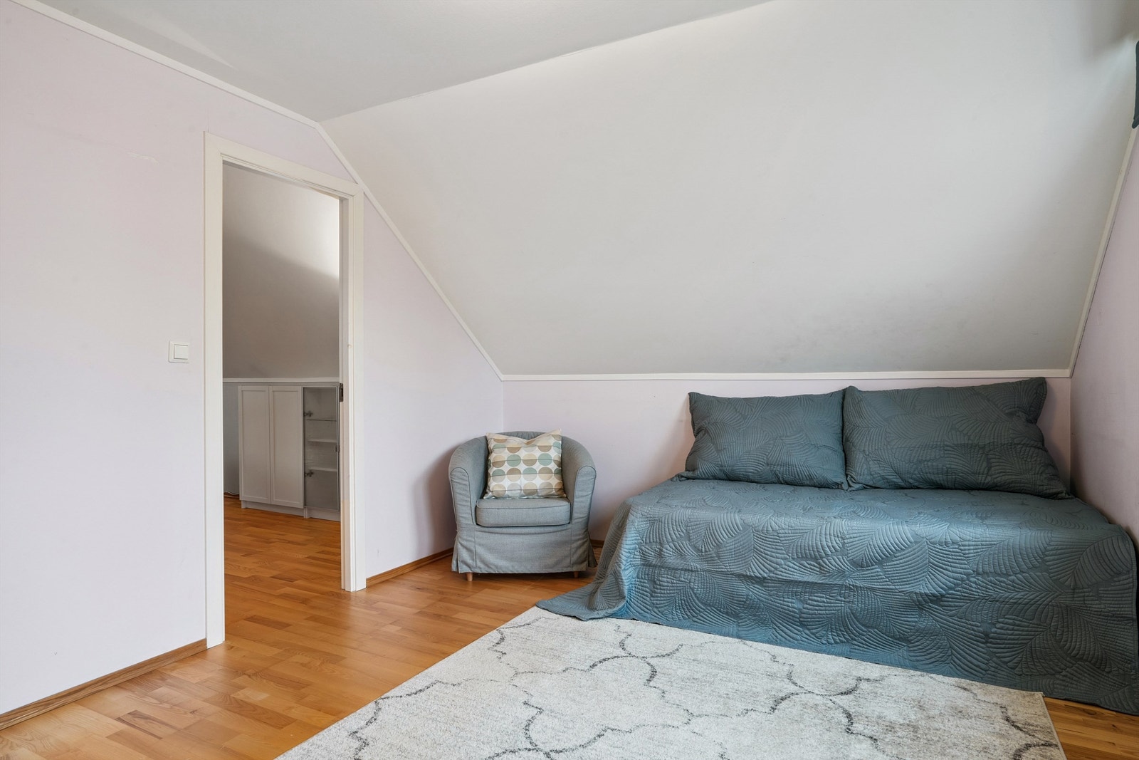 Et lunt rom med parkett på gulvet og malte veggflater. Galleribilde