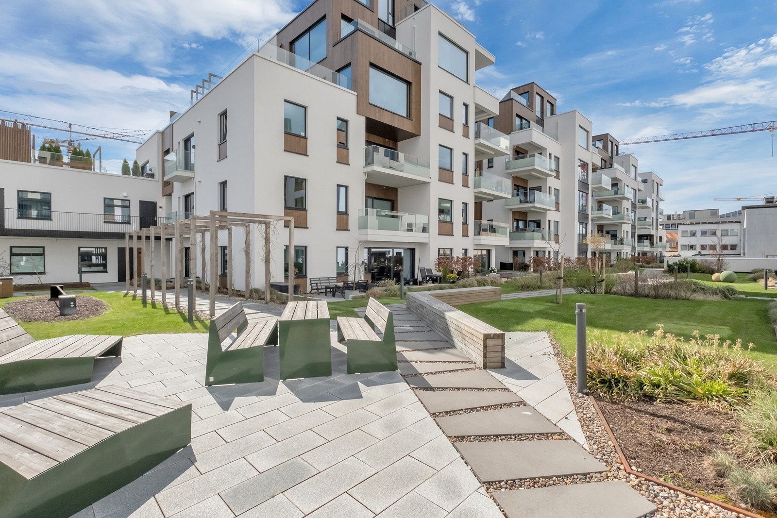 Bakgården er pent opparbeidet med prydbusker og benker Galleribilde