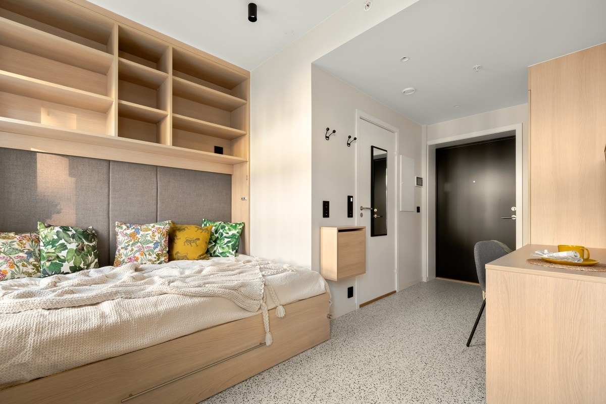 Oppredd seng og mot entré med klesskap Galleribilde