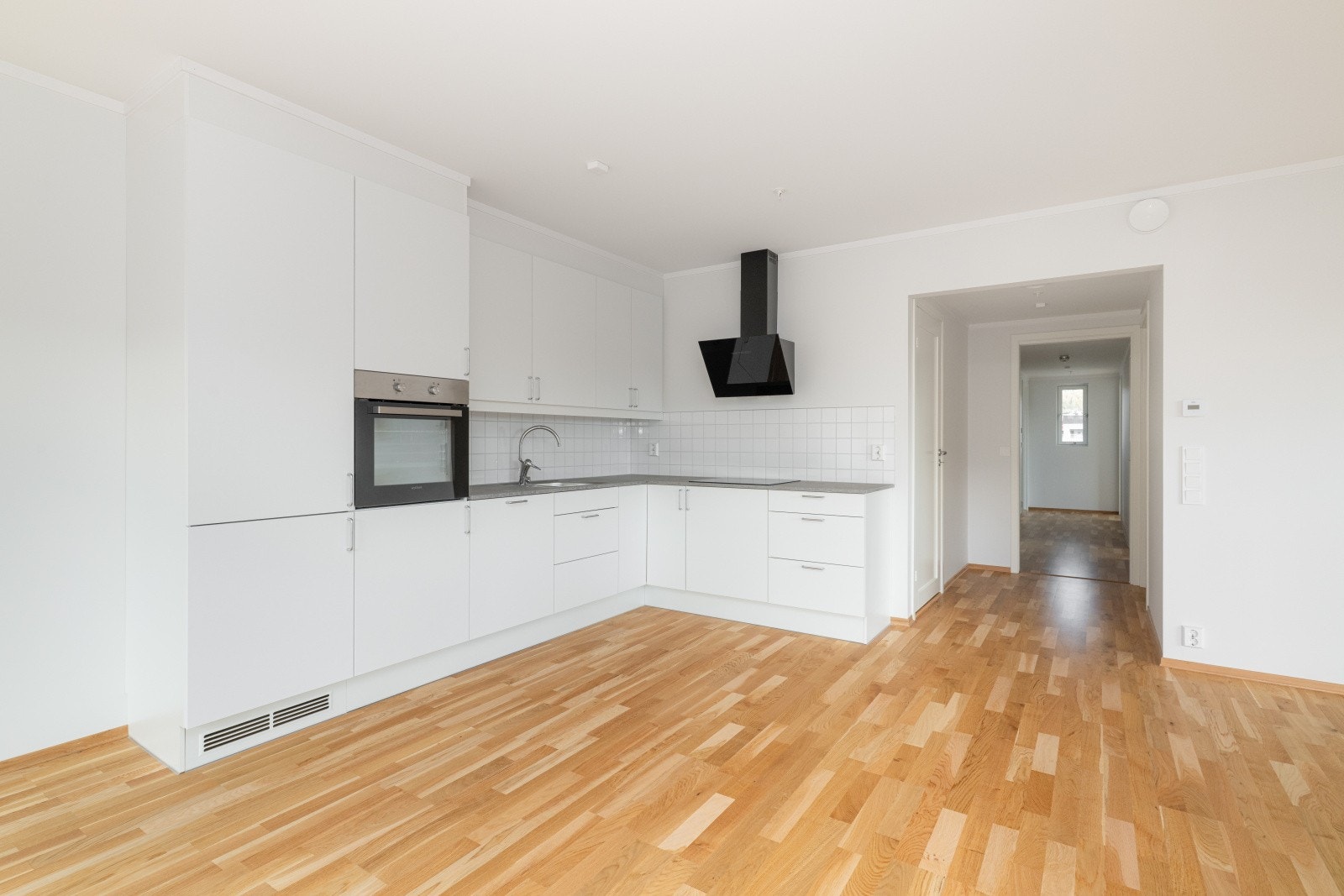 Kjøkkenet har JKE innredning med glatte fronter og benkeplate av laminat. Det er integrert kjøl/fryseskap, oppvaskmaskin, induksjonstopp, stekeovn, vannstoppsystem og komfyrvakt. Over stekesone er der ventilator med kullfilter. Galleribilde