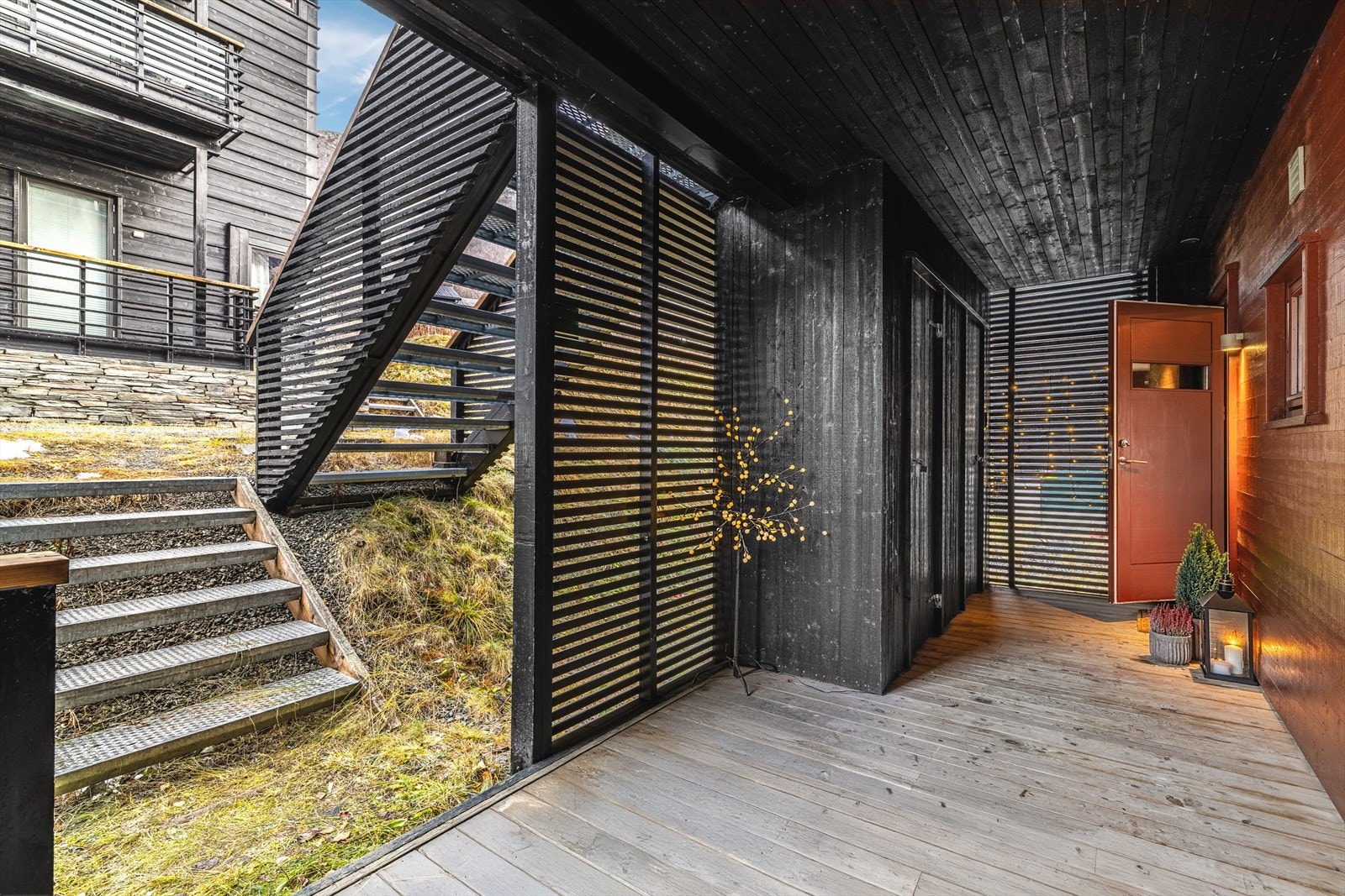 Overbygget inngangsparti med terrasseplatting. Tilgang til 2 boder. Galleribilde