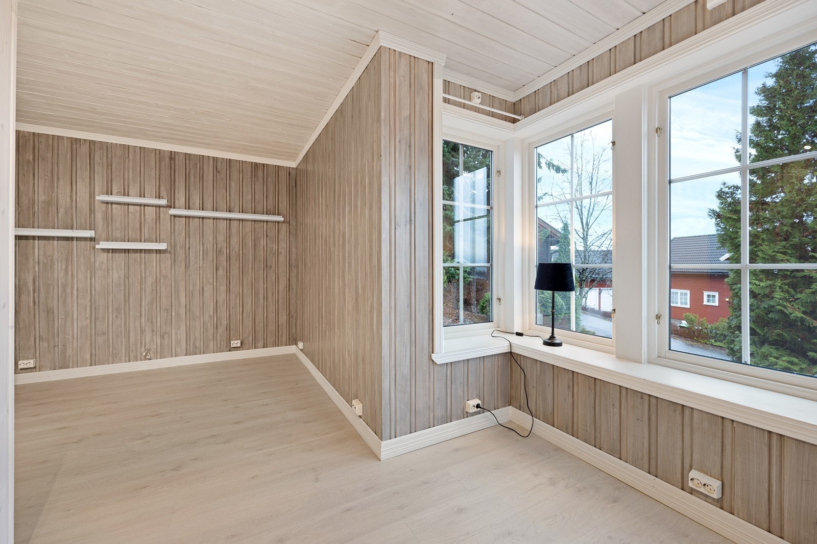 Store vindusflater gir utsyn mot hageområde. Galleribilde