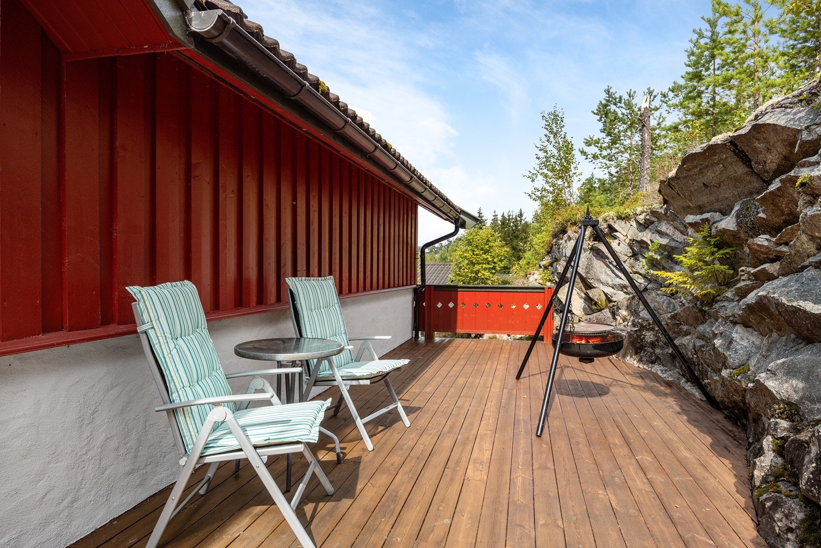 Skrånende fjellterreng omgir terrassen og gir en naturlig skjermet uteplass. Galleribilde
