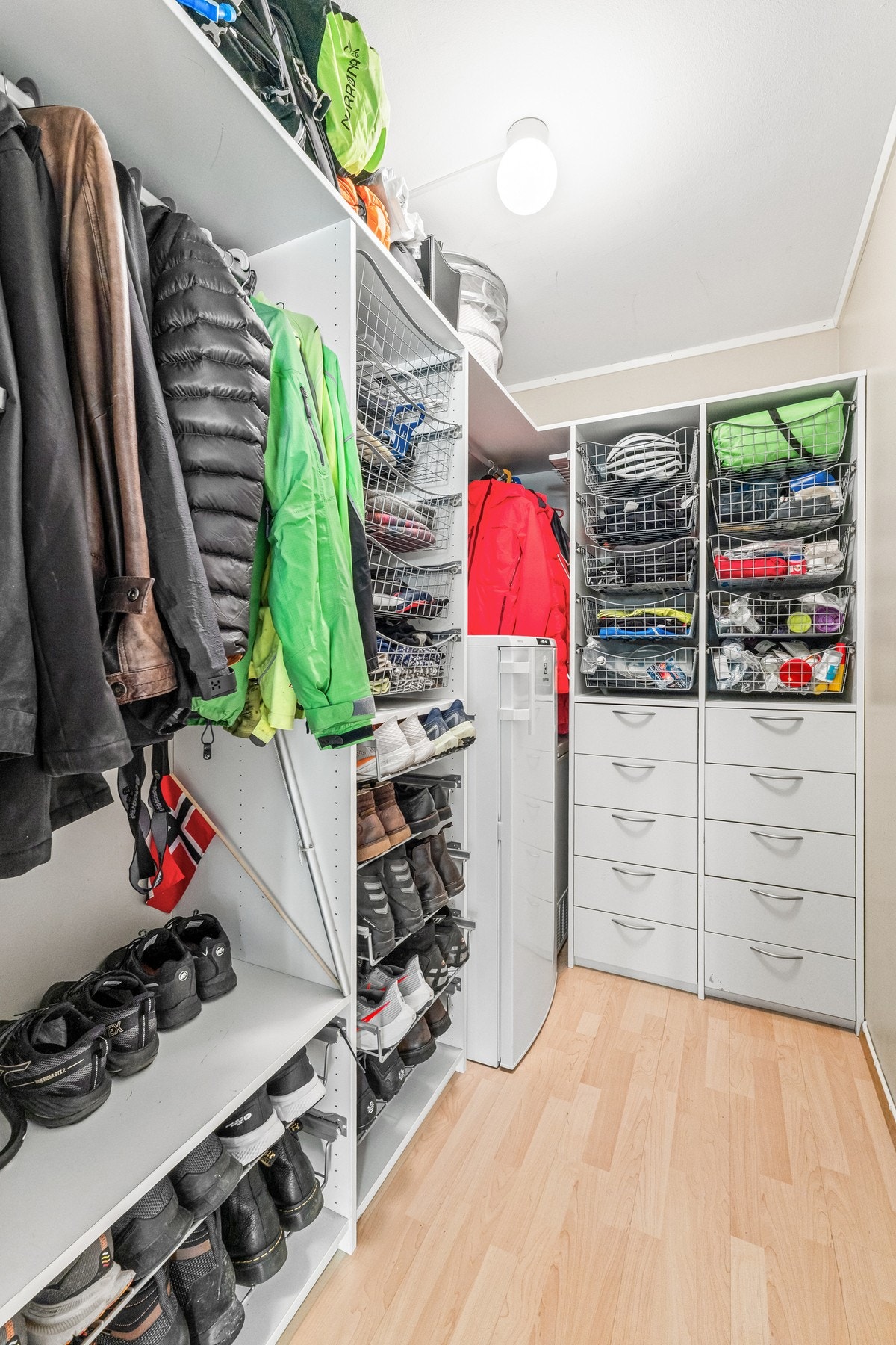 Omkledningsrom/bod med garderobeskap og plass til fryser eller ekstra kjøleskap Galleribilde