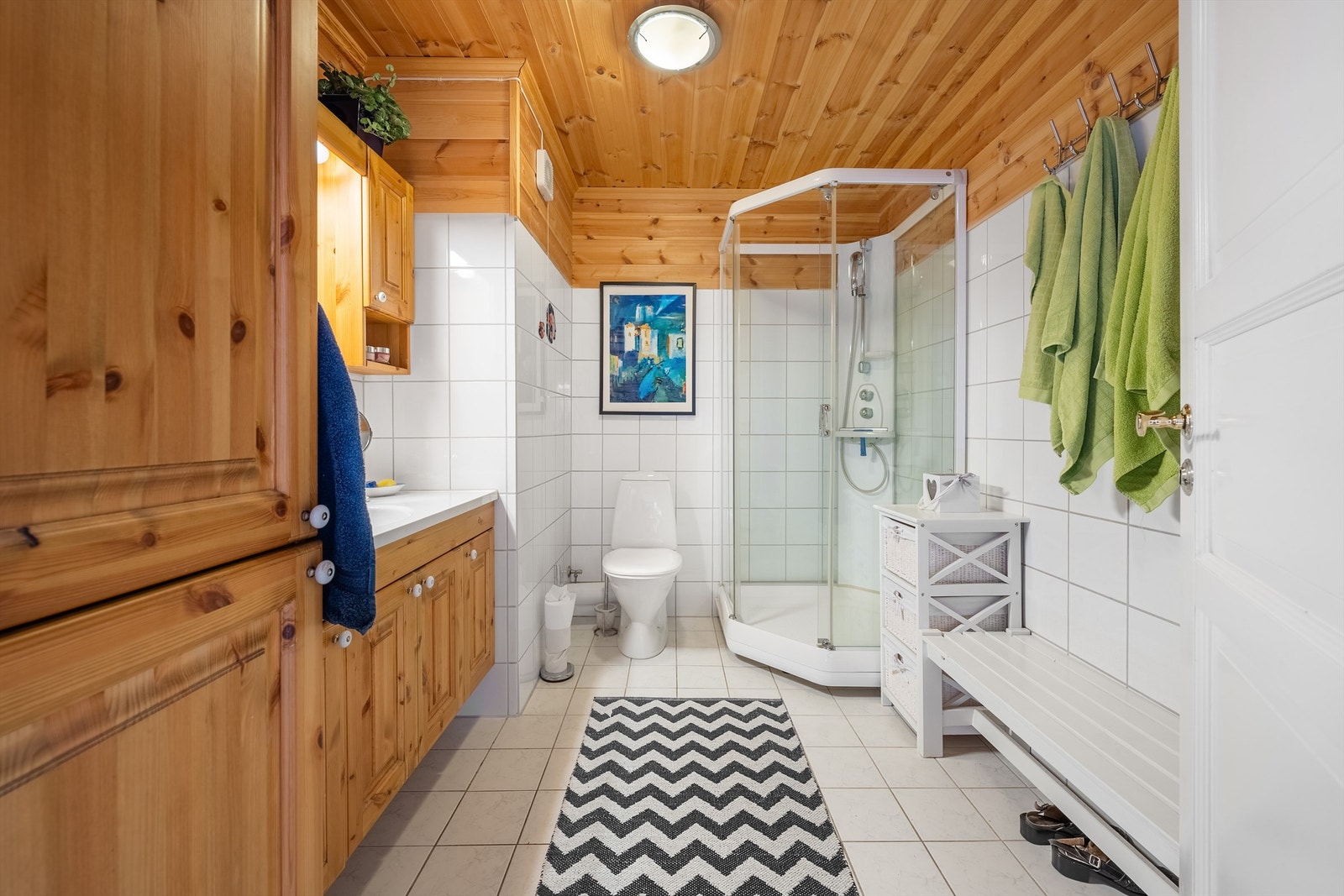 Badet i 1. etg. har servant med skap under, overskap og høyskap. Dusjkabinett, wc og opplegg for vaskemaskin. Galleribilde