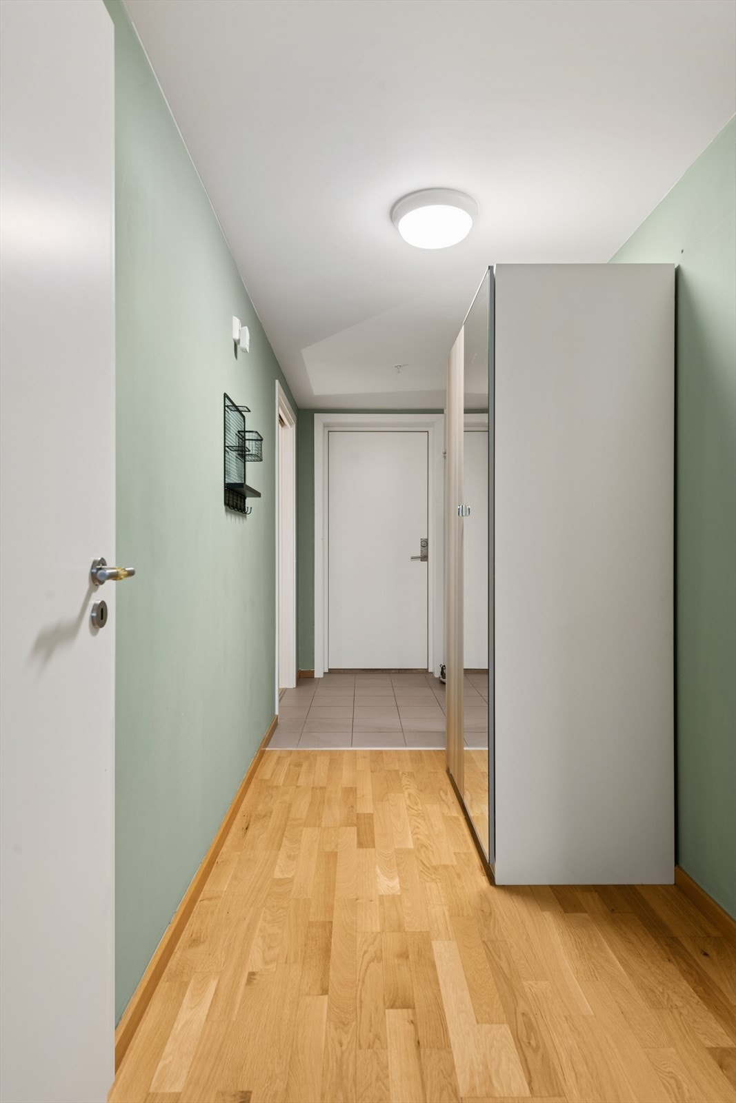 Du kommer inn i entréen, som har fliser på gulv ved dørpartiet. Ellers er det innredet med garderobeskap og plass til knaggrekke, skohylle el.l. Galleribilde