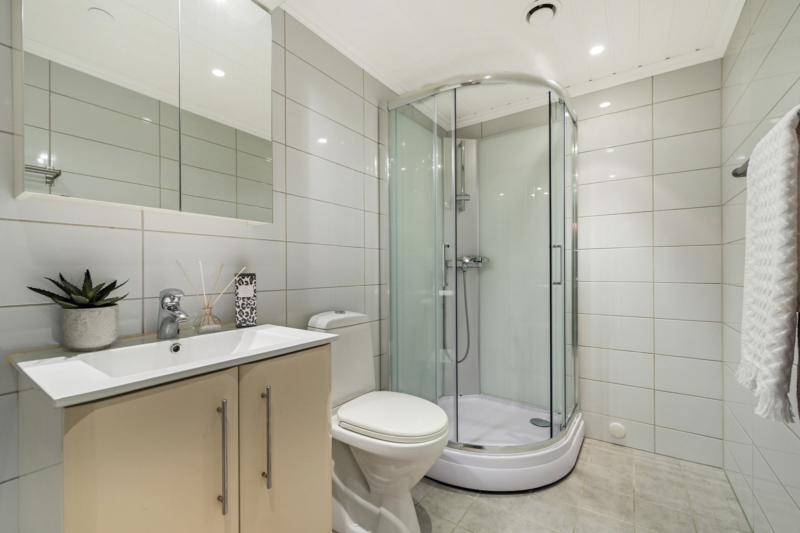 Badet er innredet med nedfelt servant, toalett, dusjkabinett og opplegg for vaskemaskin. Galleribilde