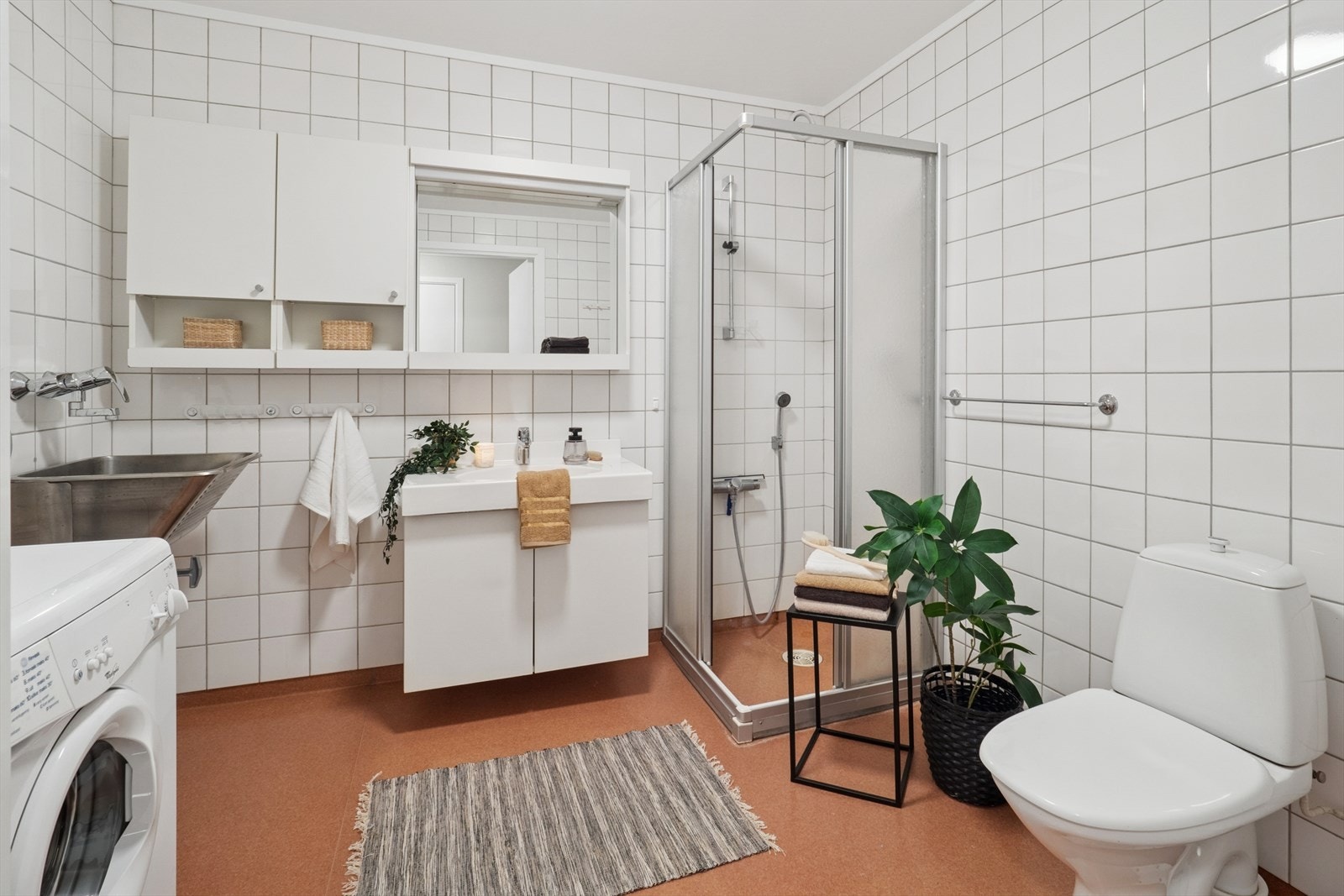 Badet er stort og praktisk, av eldre dato, med fliser på veggene og belegg på gulvet med varme. Galleribilde