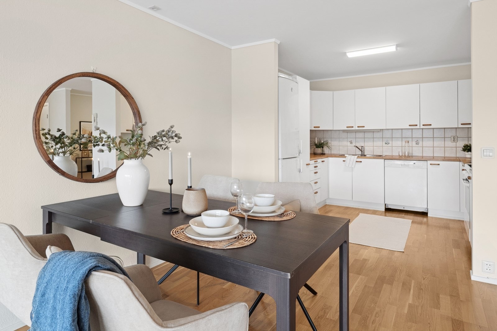 Kjøkkeninnredningen har hvite, glatte fronter og laminert benkeplate med dobbel kjøkkenkum. Galleribilde