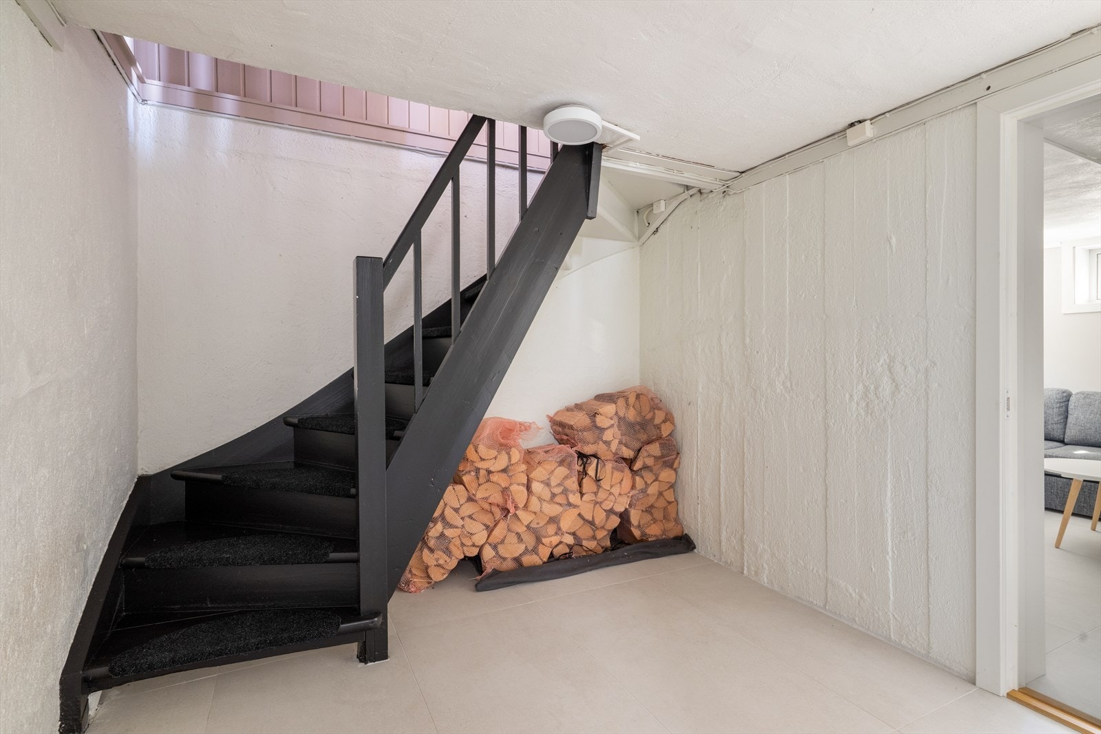 Trappegang i kjeller har gulvfliser, malte betongvegger og malt betong i tak. Galleribilde