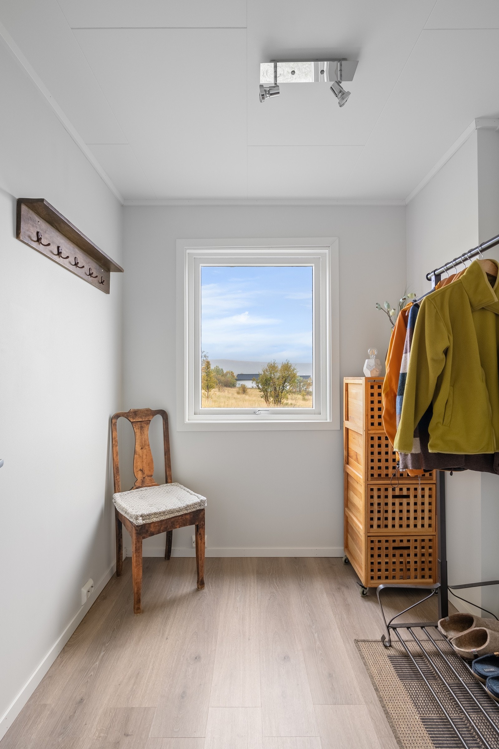 Takoverbygd inngangsparti og terrasse som strekker seg rundt tre sider av boligen. Entre/gang med gulvvarme, vegger malt i lyse farger og god plass til garderobeløsning Galleribilde