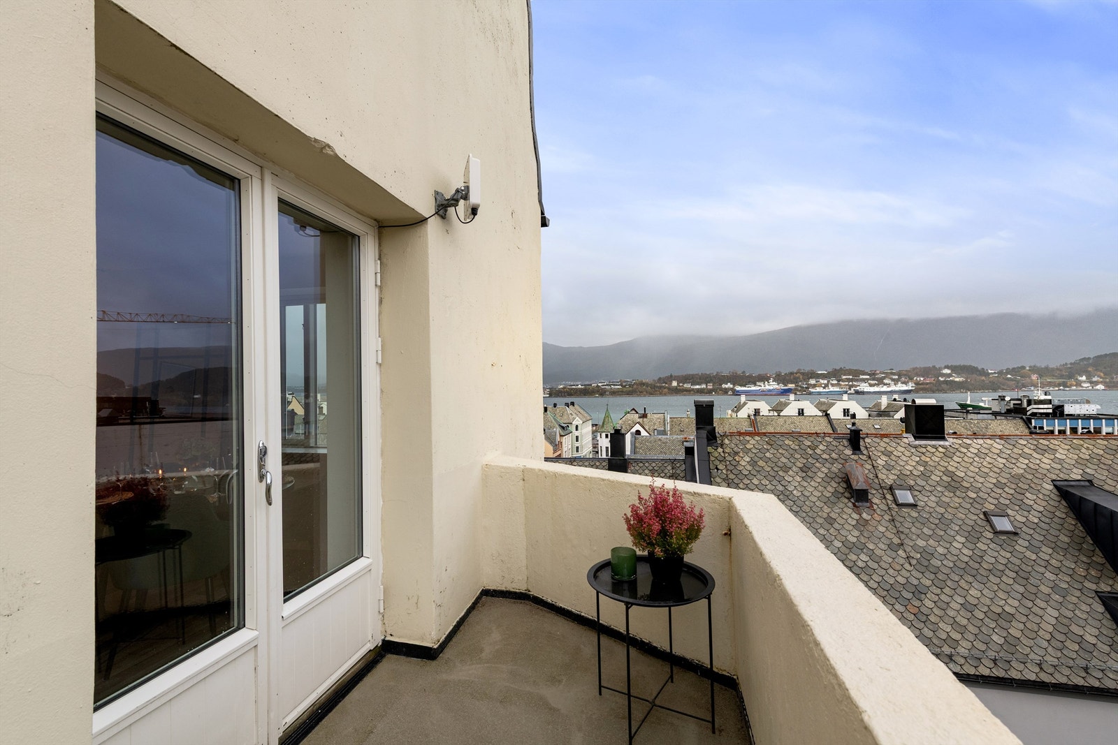 Sjarmerende balkong med flott utsikt over takene og sjøen. Perfekt for å nyte rolige stunder utendørs. Galleribilde
