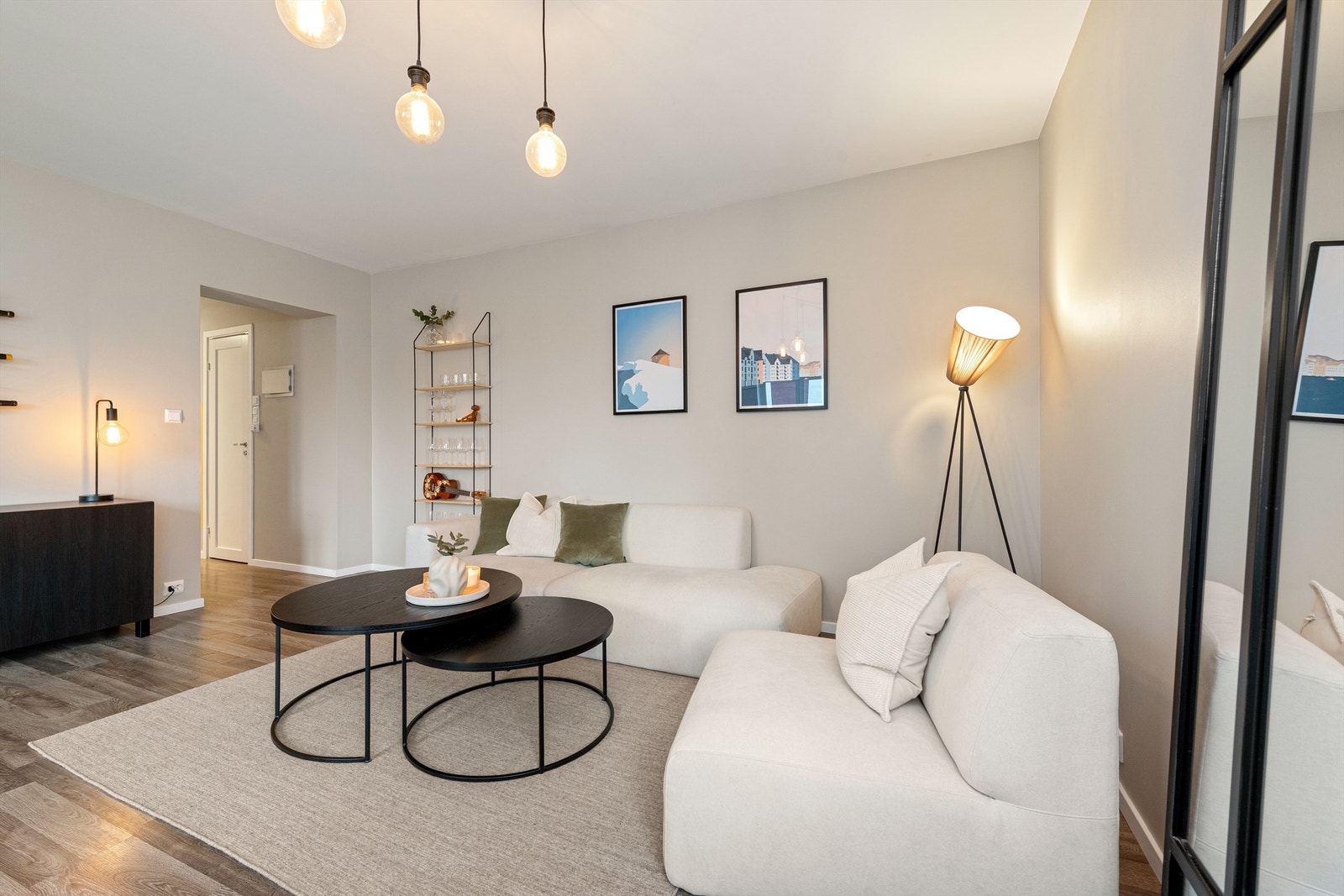 Lys og moderne stue med åpen planløsning, perfekt for avslapning og sosiale sammenkomster. Innbydende atmosfære med stilren belysning. Galleribilde