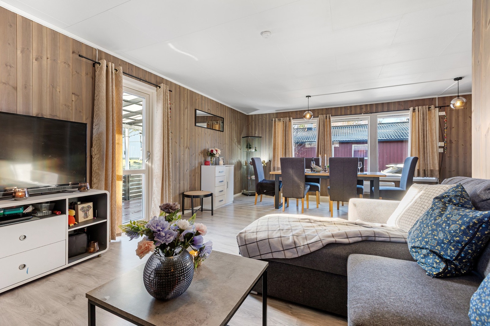 Romslig stue med store vinduer, naturlig lys og utgang til overbygd terrasse. Galleribilde